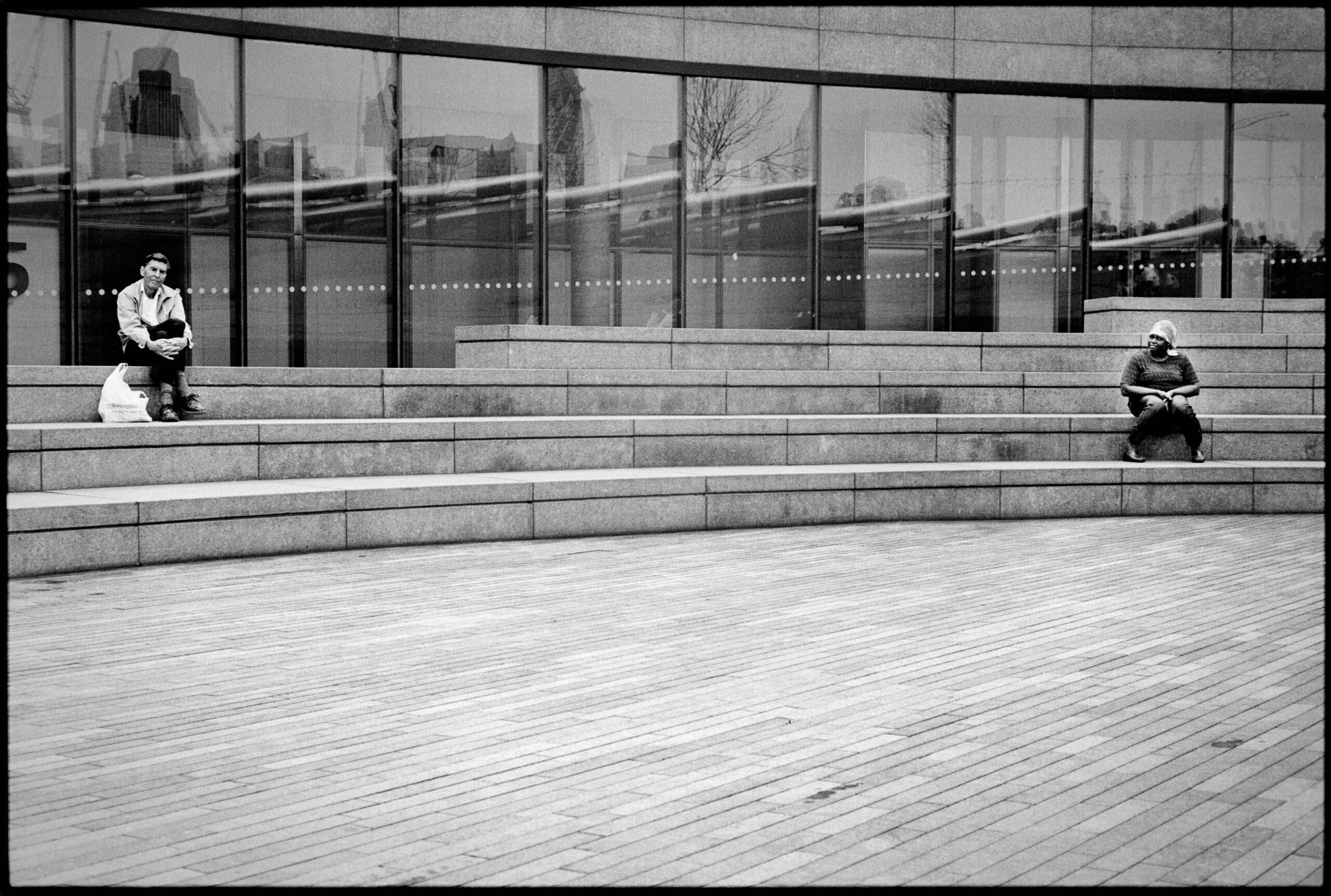 Near London City Hall there is this little agora where it is nice and easy to sit talk, have a lunch or whatever. Those two people look isolated, worlds apart from each other. And then she turns her head, maybe she looks at him, maybe not. Probably not. Who knows?